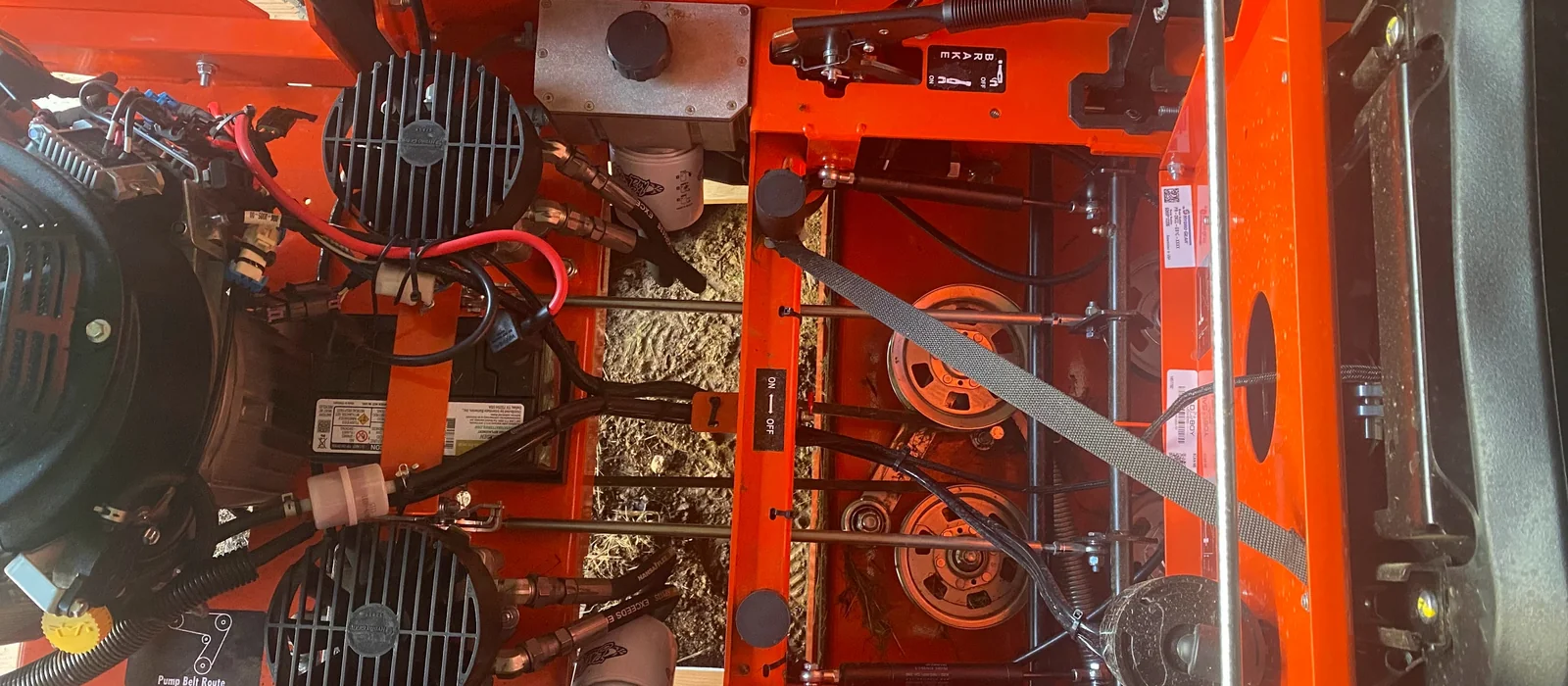 Top-down view of the engine bay — Kawasaki FX1000V V-twin, Hydro-Gear pumps, and drive belts